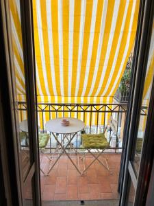 a table and chairs on a balcony with a striped tent at Elegant and beautiful apartment in Milan