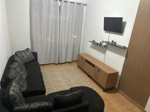 un salon avec un canapé et une télévision dans l'établissement Hotel Colombo, à São Lourenço