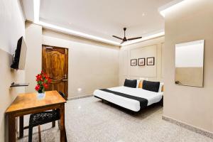 ポンディシェリにあるSuper Hotel O White Town formerly Seascape Residencyのベッドとテーブルと机のある寝室
