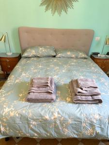 a bed with two towels sitting on top of it at Elegant and beautiful apartment in Milan