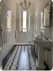 a white bathroom with a sink and a toilet at Elegant and beautiful apartment in Milan