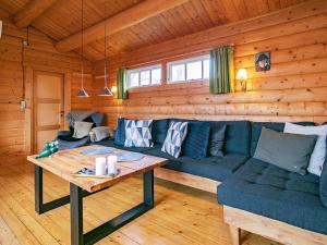 a living room with a blue couch and a table at 4 person holiday home in Assens in Assens