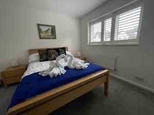 two white swans sitting on a bed in a bedroom at Riverside 2 Bedroom Townhouse with Car Charger in Abergavenny