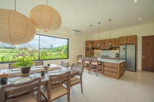 a kitchen and dining room with a table and chairs at 4BR Rice Fields view & Spa Villa Abian in Sukawati