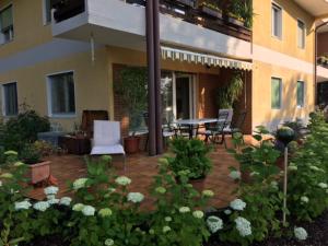 a patio with a table and chairs and flowers at Ferienwohnung Fritz in Villach