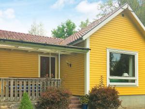 a yellow house with a porch and a window at 4 person holiday home in Rörvik in Rörvik