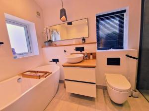 a bathroom with a sink and a toilet and a tub at 5 star Luxury Home in a Magnificent area -Chester in Hough Green