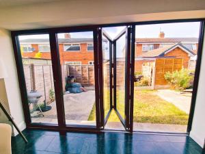 an open sliding glass door with a view of a yard at 5 star Luxury Home in a Magnificent area -Chester in Hough Green