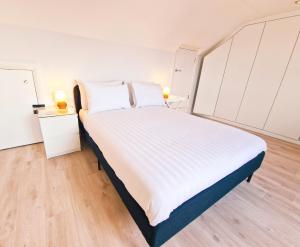 a bedroom with a large white bed with two night stands at 5 star Luxury Home in a Magnificent area -Chester in Hough Green