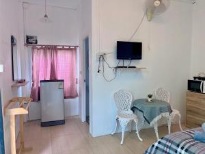 a room with a table and chairs and a television at Moon Village Khaoyai Holiday Home in Pong Talong