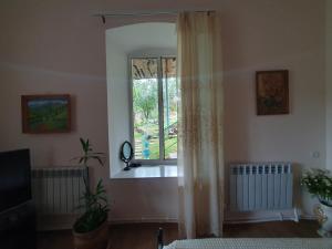 a living room with a window and a mirror at Mari-Elena in Dilijan