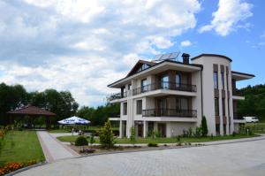 a white house with a solarium on top of it at Guesthouse Green Fields in Garmen