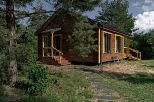 eine kleine Holzhütte mit Veranda und Gehweg in der Unterkunft Getlost cabins in Valanciunai