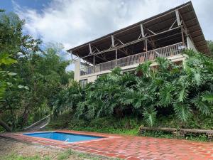 un bâtiment avec une piscine en face d'une maison dans l'établissement Eco Finca El Guadual - casa completa, à Manizales