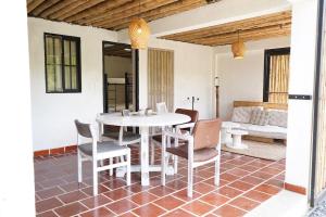 une salle à manger avec une table et des chaises blanches dans l'établissement Eco Finca El Guadual - casa completa, à Manizales