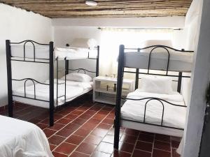 une chambre avec trois lits superposés dans une pièce dans l'établissement Eco Finca El Guadual - casa completa, à Manizales 27 autres photos