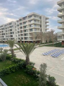 a large apartment building with lounge chairs and a pool at Sea breeze, studio apartment in Nardaran