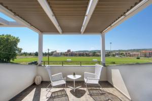 patio con mesa y sillas en el balcón en Corali luxury villas, en Ierissos