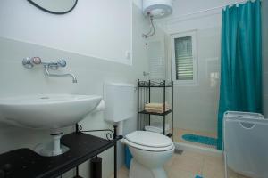 a bathroom with a white toilet and a sink at Villa Lav in Prigradica
