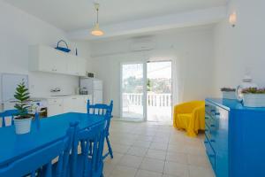a kitchen with a blue table and chairs in a room at Villa Lav in Prigradica