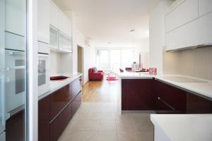 cocina con armarios blancos y sofá rojo en Apartment Vista Makarska, en Makarska