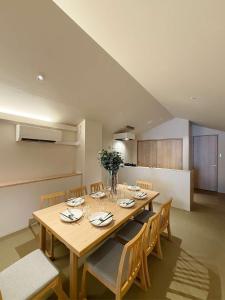 a dining room with a wooden table and chairs at b hotel Miyajima Omotesando - Sacred Island Stay 31 in Miyajima