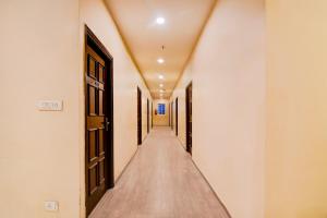 an empty corridor with doors and a long hallway at Super Townhouse Science City Formerly Hotel Mannat International in Ballygunge