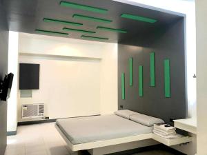 a bedroom with a bed with green lights on the wall at Astrotel Cebu in Cebu City