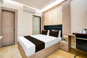 a bedroom with a large bed in a room at Super Townhouse Bairhana Road Prayagraj in Colonelganj
