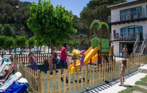 un grupo de niños jugando en un parque infantil en Medplaya Aparthotel Sant Eloi en Tossa de Mar