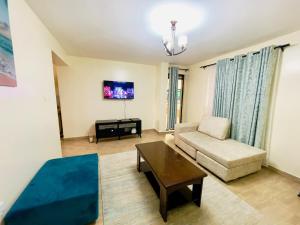 een woonkamer met een bank en een tafel bij Sweethaven in Nairobi
