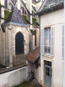 a bike parked next to a building with a window at Le Nid De La Chouette in Dijon