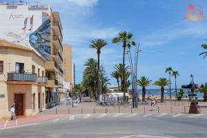una calle de la ciudad con palmeras y un edificio en Casa de la Costa - Pintor Clemente, en Santiago de la Ribera