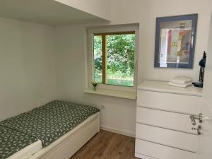 a small bedroom with a bed and a window at Naturhaus am Weiher in Hülsen