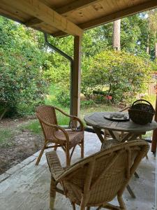 a patio with a table and chairs on a porch at Naturhaus am Weiher in Hülsen +5 photos