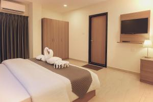 a bedroom with a bed with towel animals on it at HOTEL SSK PRIME in Vijayawāda