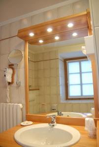 a bathroom with a sink and a large mirror at Hotel Sport in Santa Caterina Valfurva