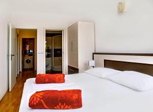 um quarto com uma grande cama branca com almofadas vermelhas em Apartment Lejo em Omiš