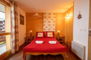 una camera con letto rosso e 2 cuscini di Cimes 2 #21 - 6 guests a Méribel