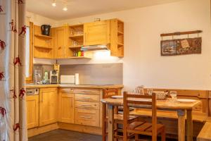 una cucina con mobili in legno e un tavolo con sedie di Cimes 2 #21 - 6 guests a Méribel