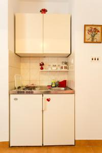 cocina con armarios blancos y encimera en Apartments Afrodita, en Dubrovnik