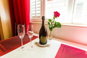 una botella de vino y dos copas de vino en una mesa en Apartments Afrodita, en Dubrovnik