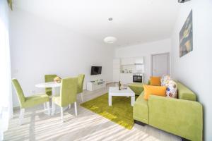 een woonkamer met een groene bank en een tafel bij Nautilus Apartments in Dobra Voda