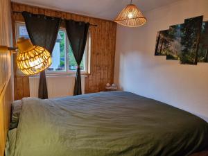 a bedroom with a bed and two lamps and a window at Appartement cocooning in Wackenbach