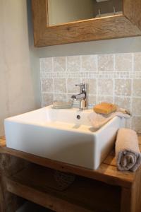 ein weißes Waschbecken auf einem Holztisch im Bad in der Unterkunft A l´Ombre Du Clocher in Montbliart