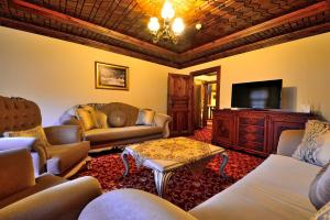 a living room with couches and a flat screen tv at Baglar Saray Hotel in Safranbolu