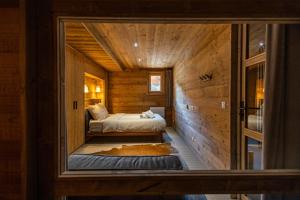 メリベルにあるChalet Achillée 5 Bedroomsの木造キャビン内のベッド1台が備わる小さな客室です。 +43枚の写真