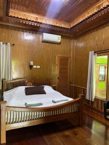 a bedroom with a bed in a wooden room at Baan Nara Homestay - Koh Kood in Ko Kood