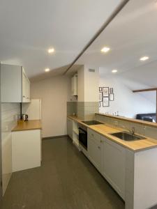 a large kitchen with white cabinets and a sink at newTown City Center Apartment Kaunas in Kaunas