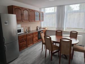 a kitchen with a table and chairs and a refrigerator at Hostel Diana in Wermelskirchen